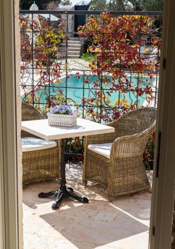 a table and chairs with a view of a pool at Dimora Graziana 1909 in Locorotondo