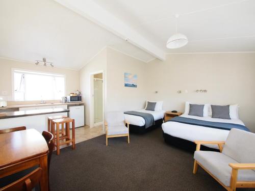 Habitación de hotel con 2 camas y cocina en Riverlodge Motel en Nelson