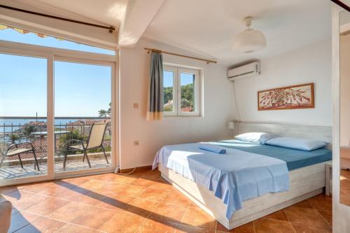 a bedroom with a bed and a balcony at Apartmani Olga in Petrovac na Moru