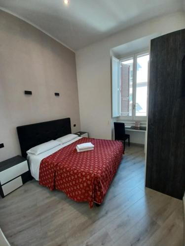 a bedroom with a bed with a red comforter at Hotel Mimosa Pantheon in Rome