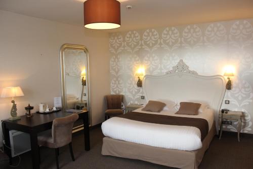 a bedroom with a bed and a desk and a mirror at Clos De La Vaupalière - Rouen in La Vaupalière