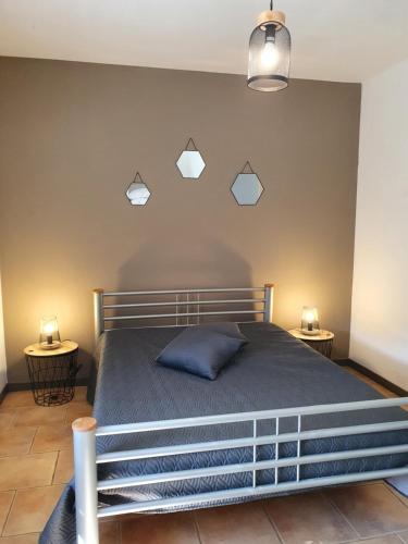 - une chambre avec un lit et trois lumières sur le mur dans l'établissement Le Hameau des Cardenals, à Salviac