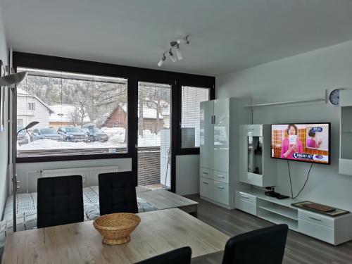 sala de estar con mesa de comedor y TV en Apartma Kuhar, en Kranjska Gora