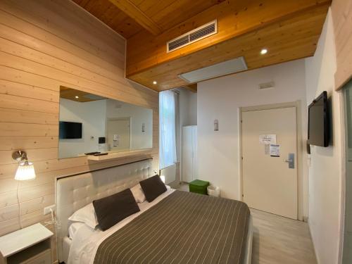 1 dormitorio con cama, espejo y TV en White albergo diffuso Ristorante & SPA, en Foggia