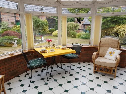 a conservatory with a table and chairs and windows at Barn Court Bed and Breakfast in Everton