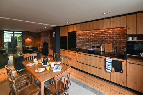 een eetkamer met een tafel en een keuken bij Opulent Georgian townhouse overlooking Spencer Square in Kent