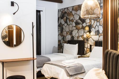 a hotel room with two beds and a mirror at The Stone Forest in Kalabaka