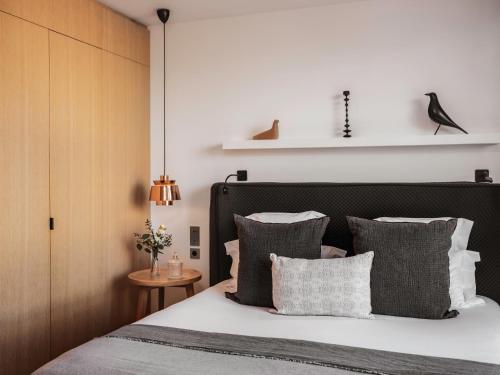 a bedroom with a bed with gray and white pillows at Balthazar Hotel & Spa Rennes - MGallery Collection in Rennes