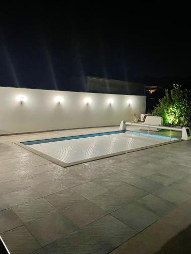- une piscine au milieu d'un patio la nuit dans l'établissement Villa élégante à Porto-Vecchio avec piscine privée, à Porto-Vecchio
