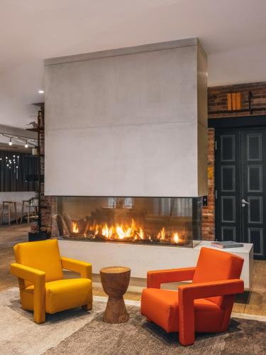 a living room with two chairs and a fireplace at Balthazar Hotel & Spa Rennes - MGallery Collection in Rennes