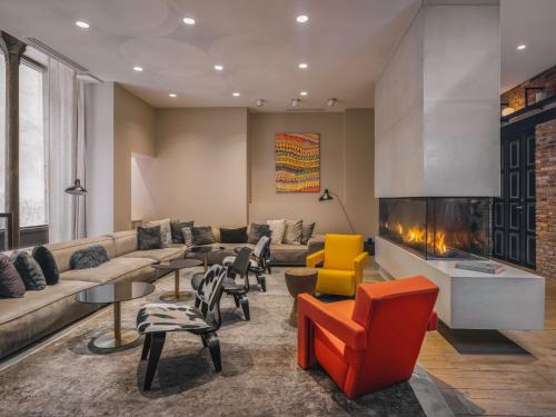 a living room with a couch and a fireplace at Balthazar Hotel & Spa Rennes - MGallery Collection in Rennes