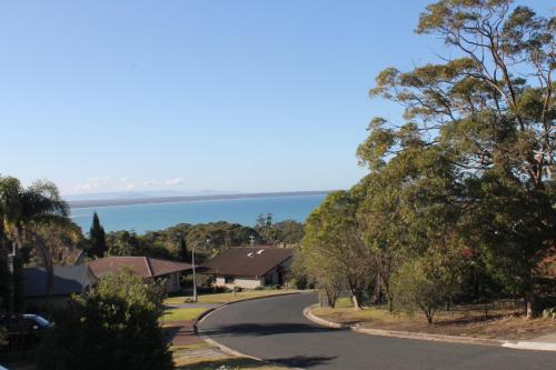 a winding road with houses and the ocean in the background at Marazul BEST DEAL - Stone Bathtub, WIFI, Functional - Mandarins and lemons when available in Vincentia