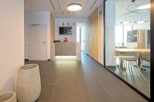 a room with a hallway with a table and chairs at DWO Yuste Alcalá in Madrid