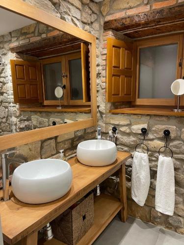 a bathroom with two sinks and a stone wall at La Solana de Mogro in Mogro