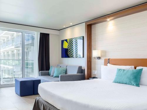 a hotel room with a large bed and a large window at Sonesta Maho Beach All Inclusive Resort Casino & Spa in Maho Reef