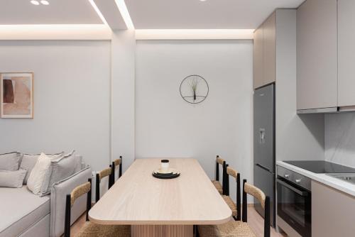een keuken met een houten tafel en stoelen bij Acropolis White Key Residence in Athene