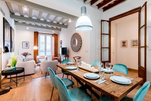 a dining room and living room with a table and chairs at Genteel Home San Antonio in Cádiz