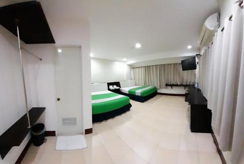 a hotel room with two beds and a television at Park Avenue Residence Inn and Suites in Davao City