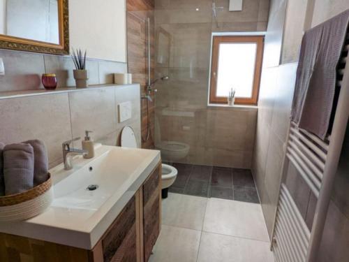 a bathroom with a sink and a toilet at Landhaus Glücksmoment in Rottau