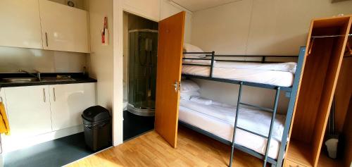two bunk beds in a small room with a kitchen at Kingussie Garden Cabins in Kingussie