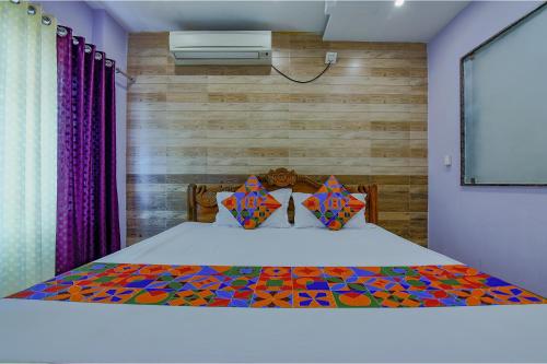 um quarto com uma cama e uma parede de madeira em FabHotel New Central em Bhubaneshwar