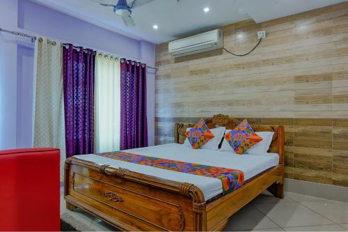 una camera con un letto e una parete in legno di FabHotel New Central a Bhubaneshwar