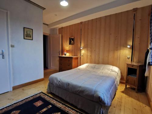 a bedroom with a bed and a wooden wall at La Tirelire in Cosswiller