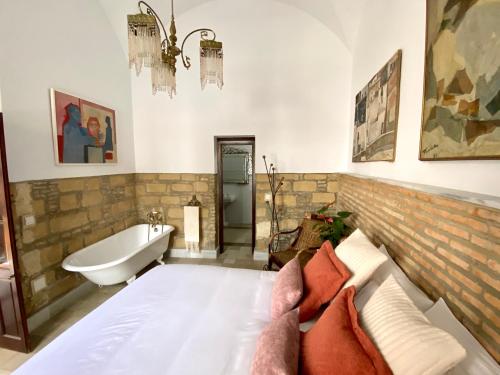 Casa Palacio Ánima في خيريز دي لا فرونتيرا: غرفة نوم مع حوض استحمام وسرير وحوض استحمام