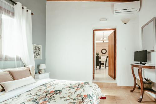 a bedroom with a bed and a tv and a mirror at Casa del Maestro in Prinés