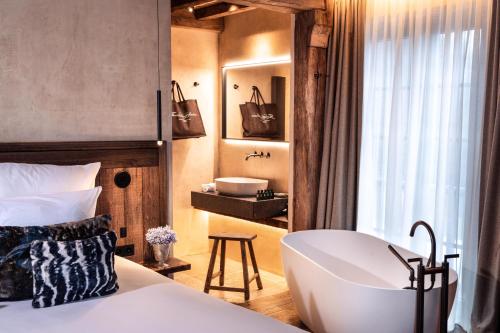 a bedroom with a tub and a sink and a bed at La Ferme Saint Simeon Spa - Relais & Chateaux in Honfleur