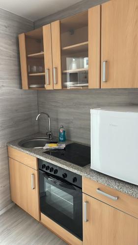 a kitchen with a sink and a stove at FEWO Grevensmühlen in Grevesmühlen