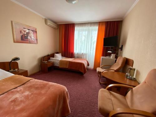 una camera d'albergo con due letti e un divano di Dnipro Hotel a Čerkasy
