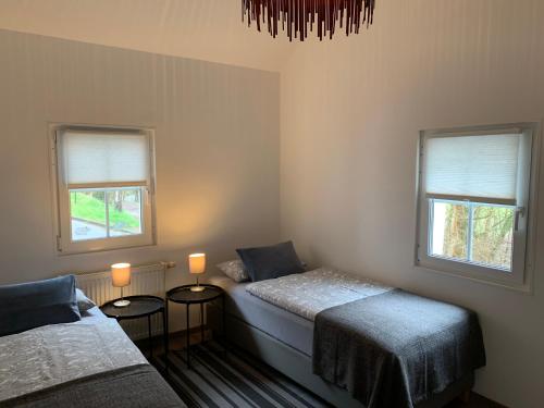 um quarto com 2 camas e 2 janelas em Ferienhaus Gemünd em Schleiden