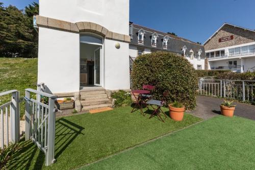 une cour avec une clôture blanche et de l'herbe dans l'établissement La Tour du Castel Beach - 200m de la plage, à Moëlan-sur-Mer