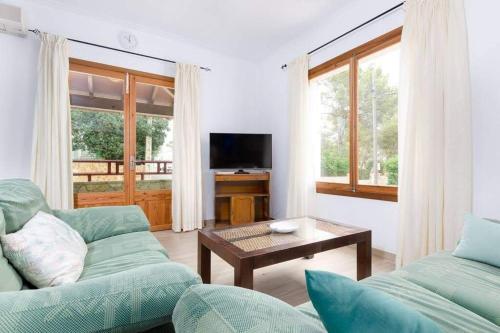 ein Wohnzimmer mit 2 Sofas und einem TV in der Unterkunft Villa Dolphin by Slow Villas in Sa Ràpita