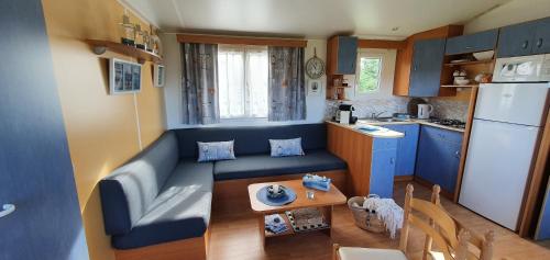 une petite cuisine avec un canapé bleu et une table dans l'établissement La quinta olac acogedor bungalow independiente, à Pedreira