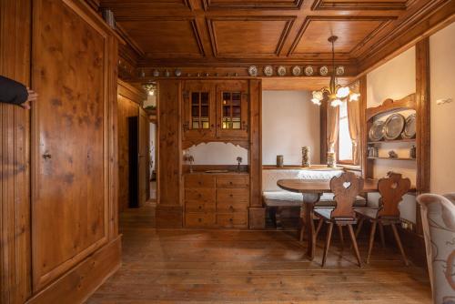 a kitchen with wooden walls and a table and chairs at Casa Regoiettes in San Vito di Cadore