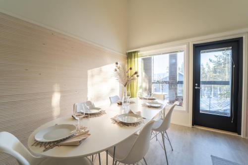 a white dining room with a white table and chairs at Hilmantori Apartments by Hiekka Booking in Kalajoki