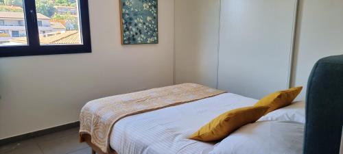 ポルト・ヴェッキオにあるAppartement d'une chambre avec vue sur la mer et wifi a Porto Vecchio a 5 km de la plageのベッドルーム1室(黄色い枕のベッド1台付)