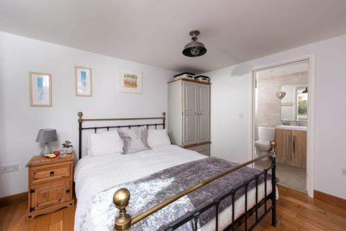 a bedroom with a large bed and a bathroom at Driftwood, Carbis Bay in Carbis Bay