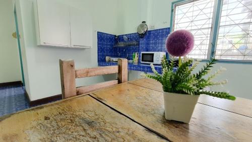 uma cozinha com uma mesa de madeira com uma planta em Karon house 15A em Praia de Karon