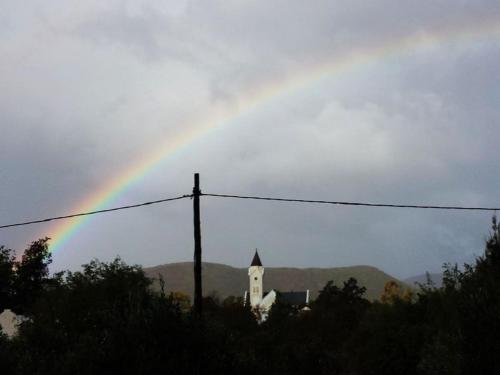 a rainbow in the sky with a church and a building at The Barn, McGregor in McGregor