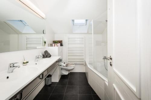 a bathroom with a sink and a toilet and a tub at Zweistapfenweg 9a in Oberstdorf