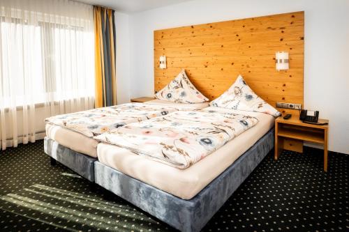 a bedroom with a large bed with a wooden headboard at Zweistapfenweg 9a in Oberstdorf