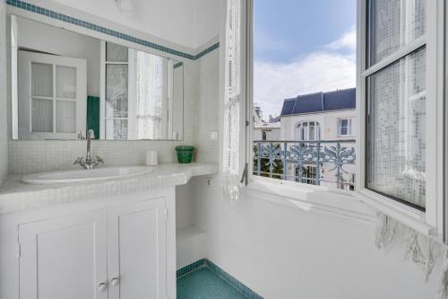 une salle de bain blanche avec un lavabo et une fenêtre dans l'établissement Comfortable house with terrace for 5 people by Wee, à Paris