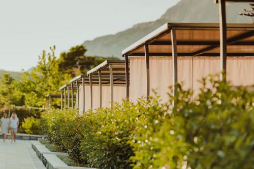 a couple walking down a sidewalk next to a row of buildings at Poseidon Mobile Home Resort in Makarska