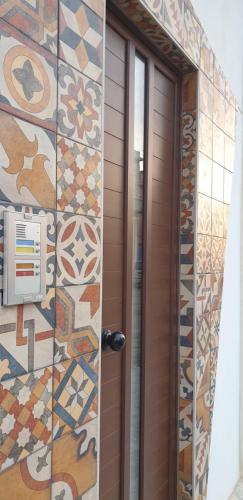 una puerta marrón con azulejos coloridos en una pared en RgB_Apartments en Lampedusa