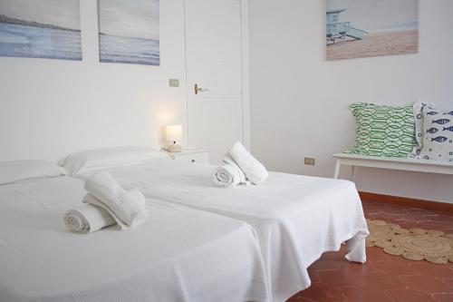 Dos camas en una habitación blanca con toallas. en Cozy marine & spa villa, en Cambrils
