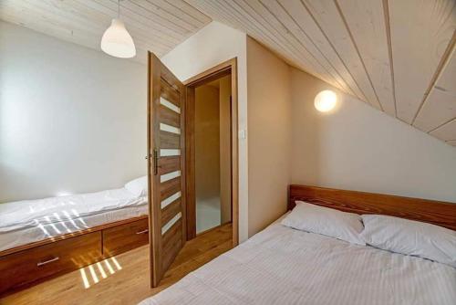 um quarto com uma cama e uma porta aberta em Domki Solina Róża Wiatrów em Solina