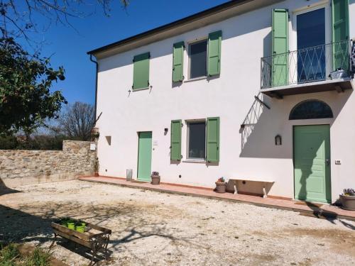 a large white house with green shutters at La Casa Vecchia Bed&Breakfast in Caniparola di Fosdinovo